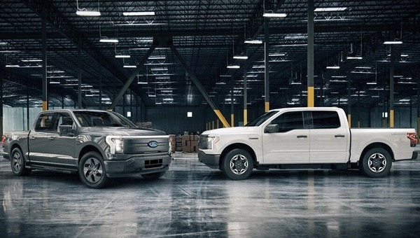 Two 2022 Ford F one Fifty Lightning Pros parked inside a warehouse