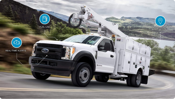 Ford Pro service utility truck driving on a winding road with icons for real-time alerts and location tracking.
