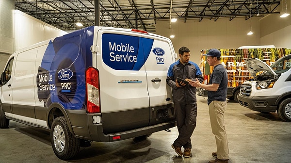 Ford Pro Mobile Service van with technicians assisting customer.