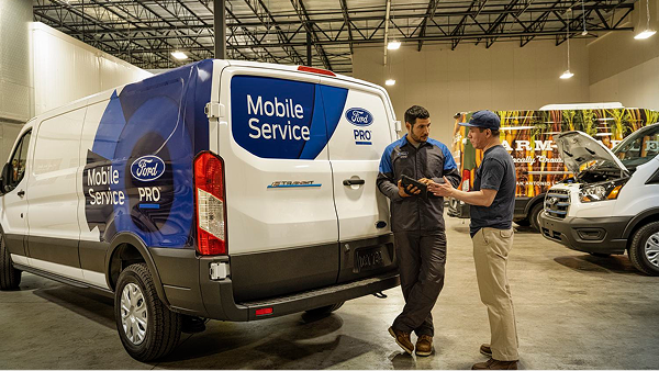 Ford Pro Mobile Service van with technicians assisting customer.