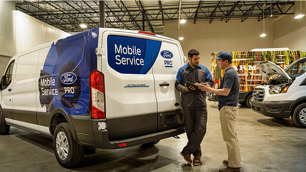 Ford Pro Mobile Service van with two technicians discussing repairs.