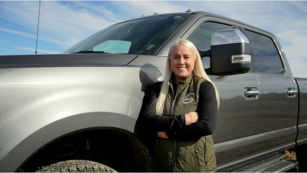 Jessica Cox from Grade A Construction standing beside a gray Ford Super Duty truck.