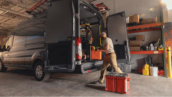 Ford Pro technician working inside upfitted van with shelving