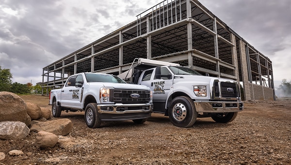 Two Ford trucks parked at a construction site.