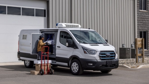 White transit van being loaded with packages.