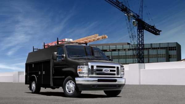 Black utility van with construction tools parked in a roof top.