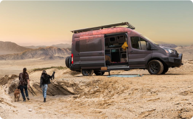 A camping group walking up to their E-transit.
