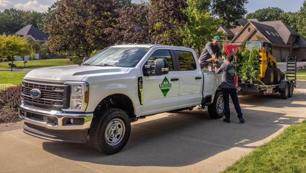A truck with people standing next to it.