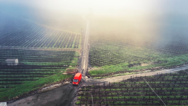 A van driving down a dirt road.